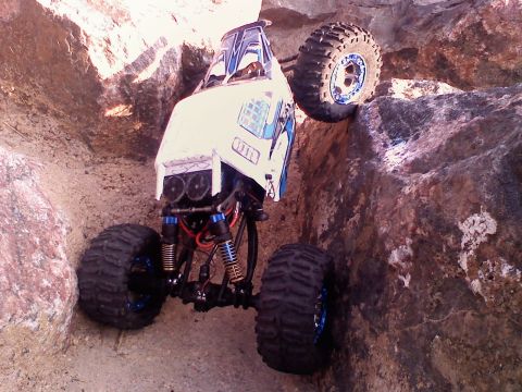 1996 Ford Bronco - A white remote control rock crawler navigates a challenging rocky terrain, its off-road capabilities.