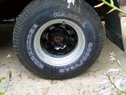 1989 Ford Bronco - A close-up view of a tire and wheel assembly on a vehicle.
