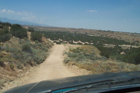 1995 Ford Bronco - View from inside a vehicle looking out at a desert scene with a dirt road ahead. Supermotors.net logo is present.