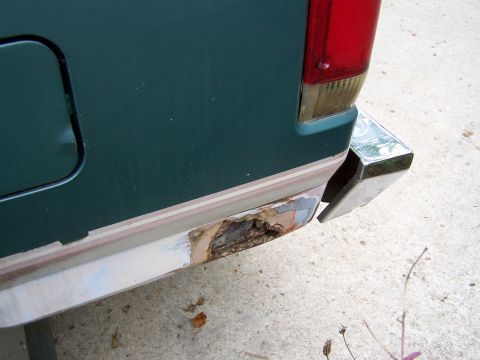 1989 Ford Bronco - The rear bumper corner of a 1989 Ford Bronco shows significant rust and damage.