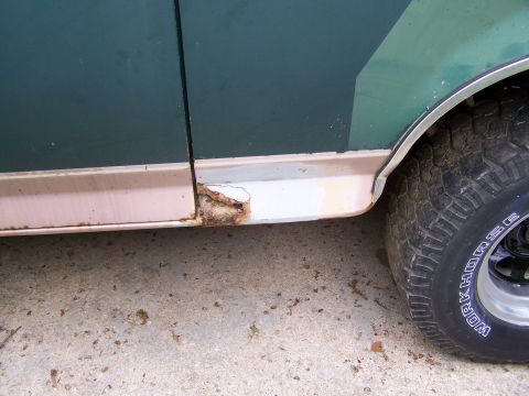 1989 Ford Bronco - Close-up of a rusted lower body panel and tire on a vehicle.