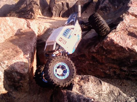 1996 Ford Bronco - A remote control rock crawler is shown maneuvering through a challenging rocky landscape.