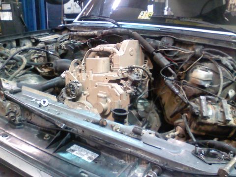 1990 Ford Bronco - Engine bay of a vehicle undergoing a diesel engine swap, with components visible.