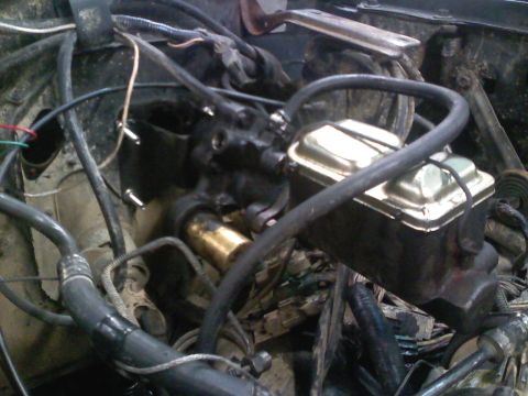 1990 Ford Bronco - Close-up view of the engine bay, focusing on the brake master cylinder and associated plumbing.