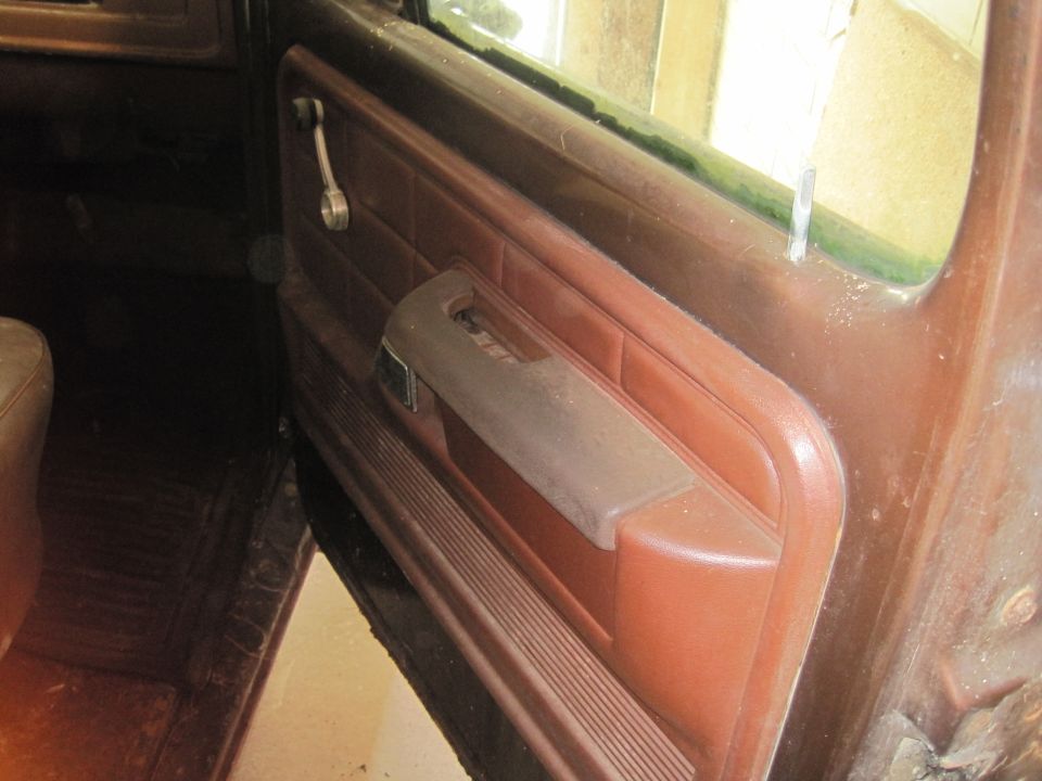 Brown interior door panel with manual window crank and armrest