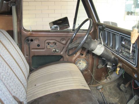 1979 Ford Bronco - Interior view of a 1979 Ford Bronco, revealing its aged dashboard, steering wheel, and door panel.