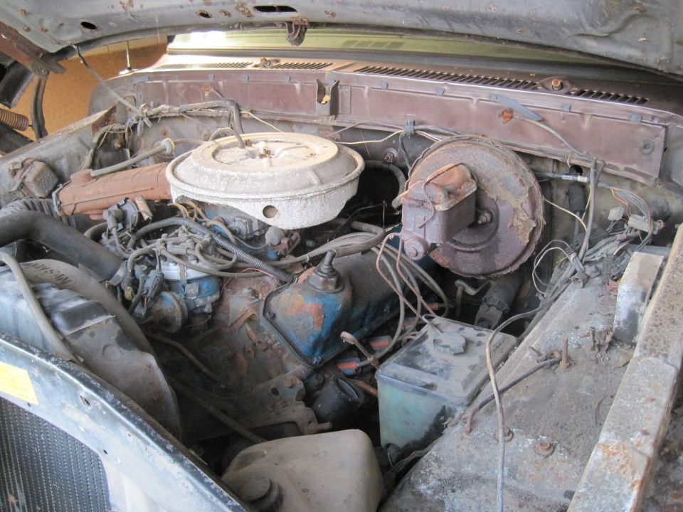 Engine bay with V8 engine, air cleaner, brake booster, and various hoses and wires