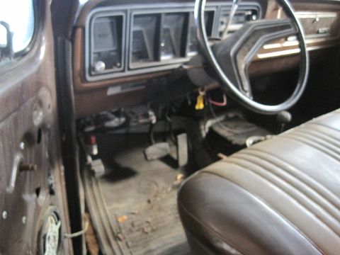 1979 Ford Bronco - The interior of this 1979 Ford Bronco features a classic dashboard and worn seats, indicative of its age.