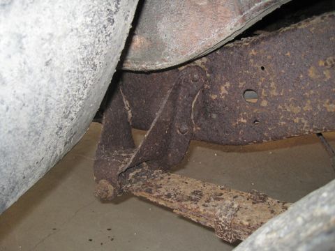 1979 Ford Bronco - Close-up of heavily rusted vehicle suspension components, showing a leaf spring and frame.