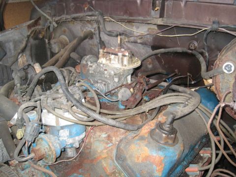 1979 Ford Bronco - Close-up view of a weathered engine bay, showing the carburetor and distributor.