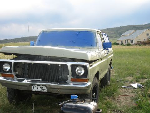 1978 Ford Bronco - Front view of a 1978 Ford Bronco, hood up, with blue tape covering the windshield.