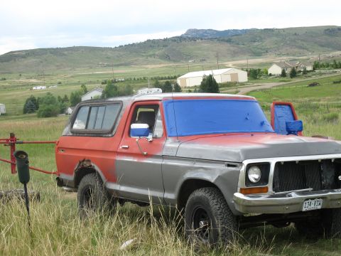 1978 Ford Bronco - This 1978 Ford Bronco is parked in a rural setting with a blue tarp covering the windshield.