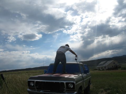 1978 Ford Bronco - Man on the hood of a 1978 Ford Bronco, possibly washing or detailing it.
