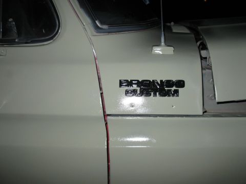 1978 Ford Bronco - Close-up of the Bronco Custom emblem on a vehicle door.