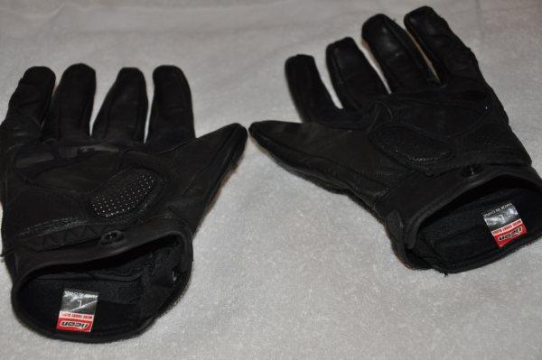 Pair of black leather motorcycle gloves with textured palms and visible ICON branding on interior tags