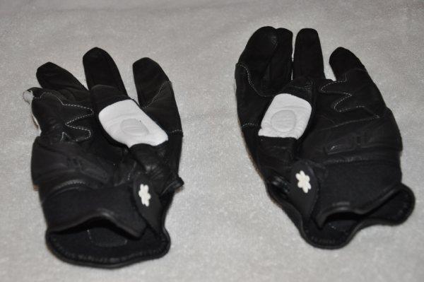 Pair of black motorcycle gloves with white accents and cloverleaf emblems