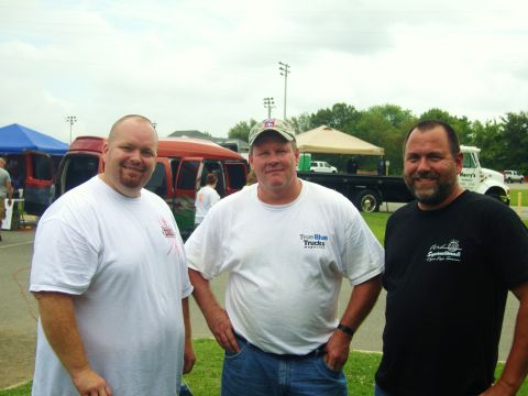 2007 Ford Mustang - Three men pose for a photo at an outdoor event with vehicles in the background.
