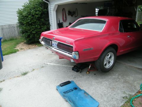 1967 Mercury Cougar - Rear view of a red 1967 Mercury Cougar being serviced in a garage.