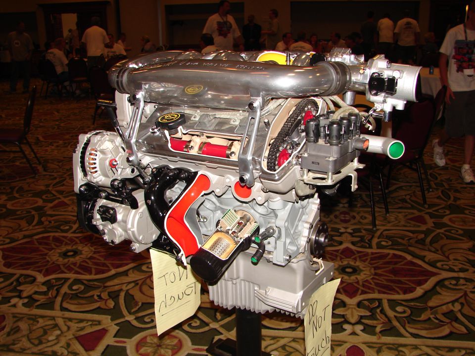 Cutaway engine with visible internal components and Supermotors.net logo