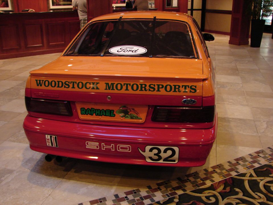 Rear of orange and red Ford Taurus SHO with racing decals and number 32