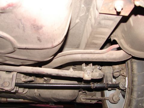 1992 Ford Taurus - The undercarriage of a vehicle is visible, revealing suspension parts and a fuel tank.
