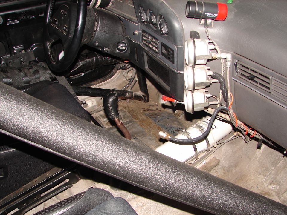 1992 Ford Taurus interior with roll cage, racing gauges, and nitrous bottle