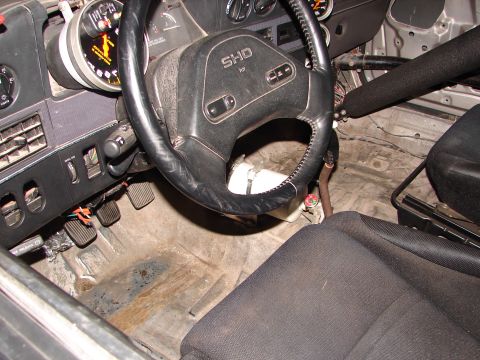 1992 Ford Taurus - The interior of a modified car shows a racing seat, roll cage, and a steering wheel with "SHO" branding.
