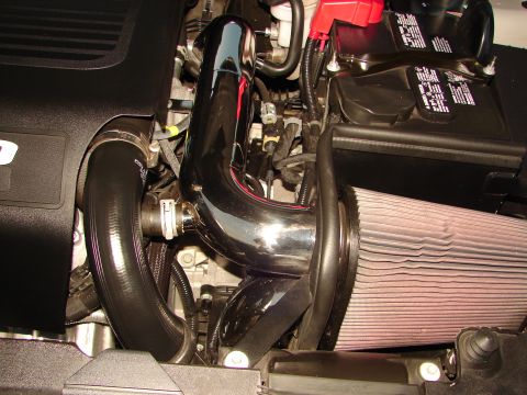 1992 Ford Taurus - Close-up of an engine bay, showing an aftermarket intake system with chrome piping and a large air filter.