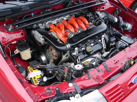 1992 Ford Taurus - The engine bay of a 1992 Ford Taurus SHO is captured, highlighting the distinctive red intake manifold and "SHO 3.0L 24 VALVE DOHC" inscrip…