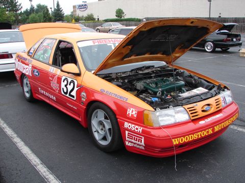 1992 Ford Taurus - A 1992 Ford Taurus race car displays its engine with the hood open, adorned with sponsor logos and the number 32.