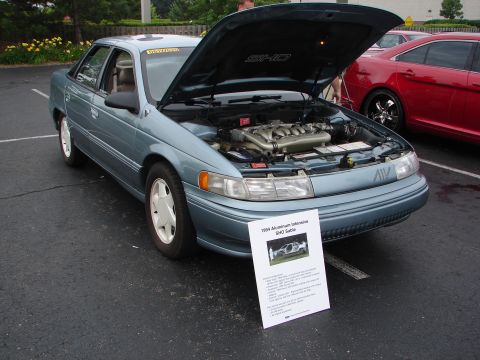 1992 Ford Taurus - A 1994 Ford Taurus SHO Sable is displayed with its hood open, next to another vehicle.
