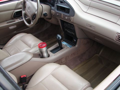1992 Ford Taurus - Interior view of a car, showing the dashboard, seats, and center console with a travel mug.