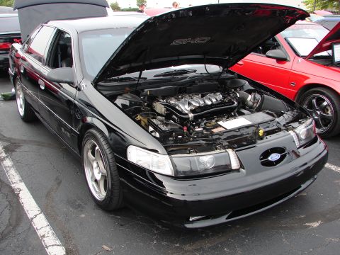 1992 Ford Taurus - 1992 Ford Taurus SHO at an event, engine bay displayed. Another car is parked nearby.