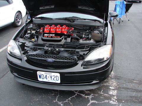 1992 Ford Taurus - A black Ford Taurus with its hood open, revealing the SHO V8 32 Valve engine, parked outdoors.