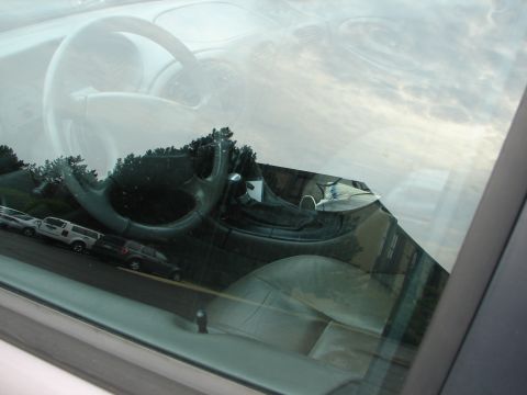 1992 Ford Taurus - The interior of a car is visible, with a reflection of the outside world on the windshield.