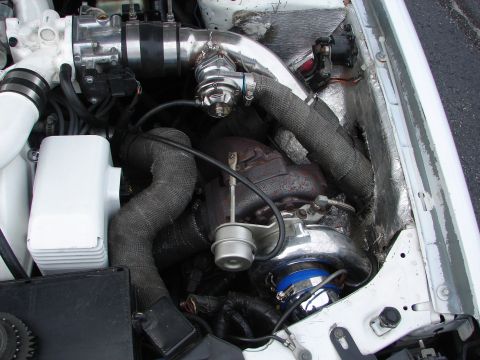 1992 Ford Taurus - Custom engine modifications including a turbocharger and associated plumbing are shown in this engine bay.