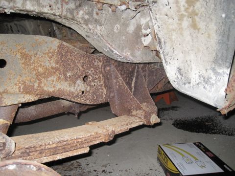 1979 Ford Bronco - The underside of a vehicle shows significant rust on the frame and suspension parts.