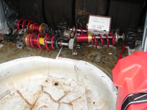 1992 Ford Taurus - Suspension components and a gas can are stored in the trunk of a vehicle.