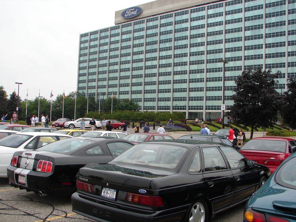 Black Ford Taurus parked in front of Ford building. License plate is KEM-720