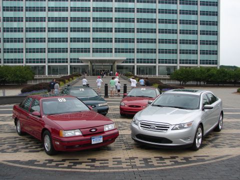 1992 Ford Taurus - Several Ford Taurus cars, including a 1992 model, are gathered in front of a large office building.