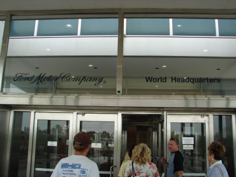 1992 Ford Taurus - A group of people are entering the Ford Motor Company World Headquarters building through the main entrance.
