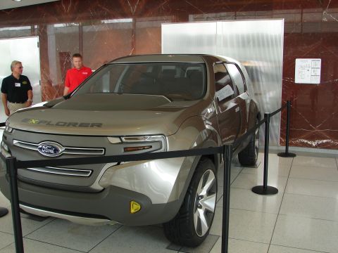 1992 Ford Taurus - A concept SUV, possibly a Ford Explorer prototype, is displayed indoors with two onlookers.