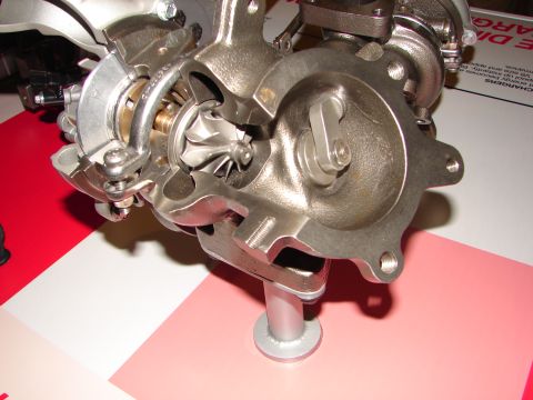 1992 Ford Taurus - This image displays a cutaway view of a turbocharger, revealing its internal components like the turbine and compressor wheels.