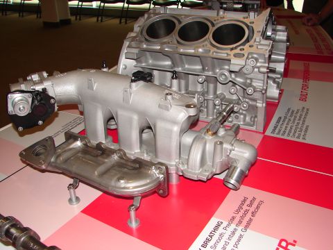1992 Ford Taurus - Engine components are displayed on a table with informational text and a website URL.