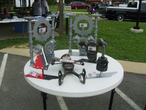 2007 Ford Mustang - Artistic display of engine parts including gears, pistons, and connecting rods on a table.