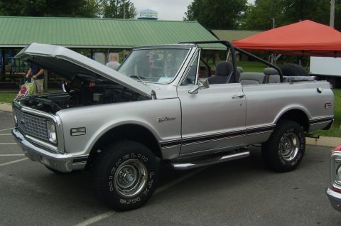 2007 Ford Mustang - A silver convertible SUV is parked with its hood open, revealing the engine bay.