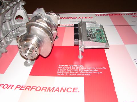 1992 Ford Taurus - A display a crankshaft and an engine control unit, highlighting advanced electronics for smooth power delivery and emissions control.