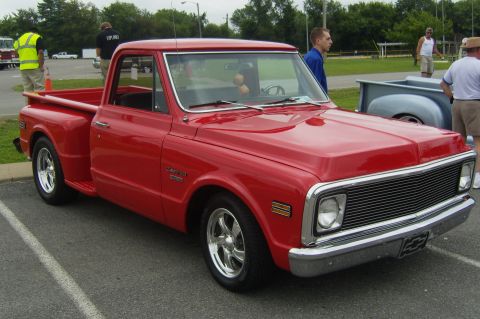 2007 Ford Mustang - A classic red pickup truck is displayed at an outdoor event.