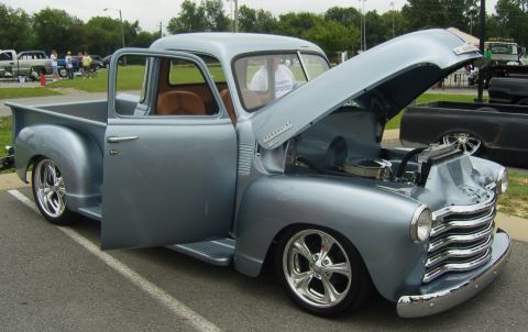 2007 Ford Mustang - A classic light blue Chevrolet pickup truck is displayed with its door and hood open at an outdoor event.