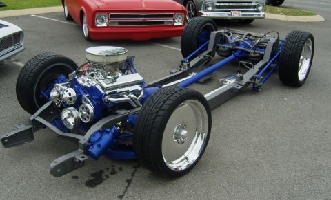 2007 Ford Mustang - A custom vehicle chassis with a prominent blue engine and chrome detailing is displayed, with other vehicles visible in the background.